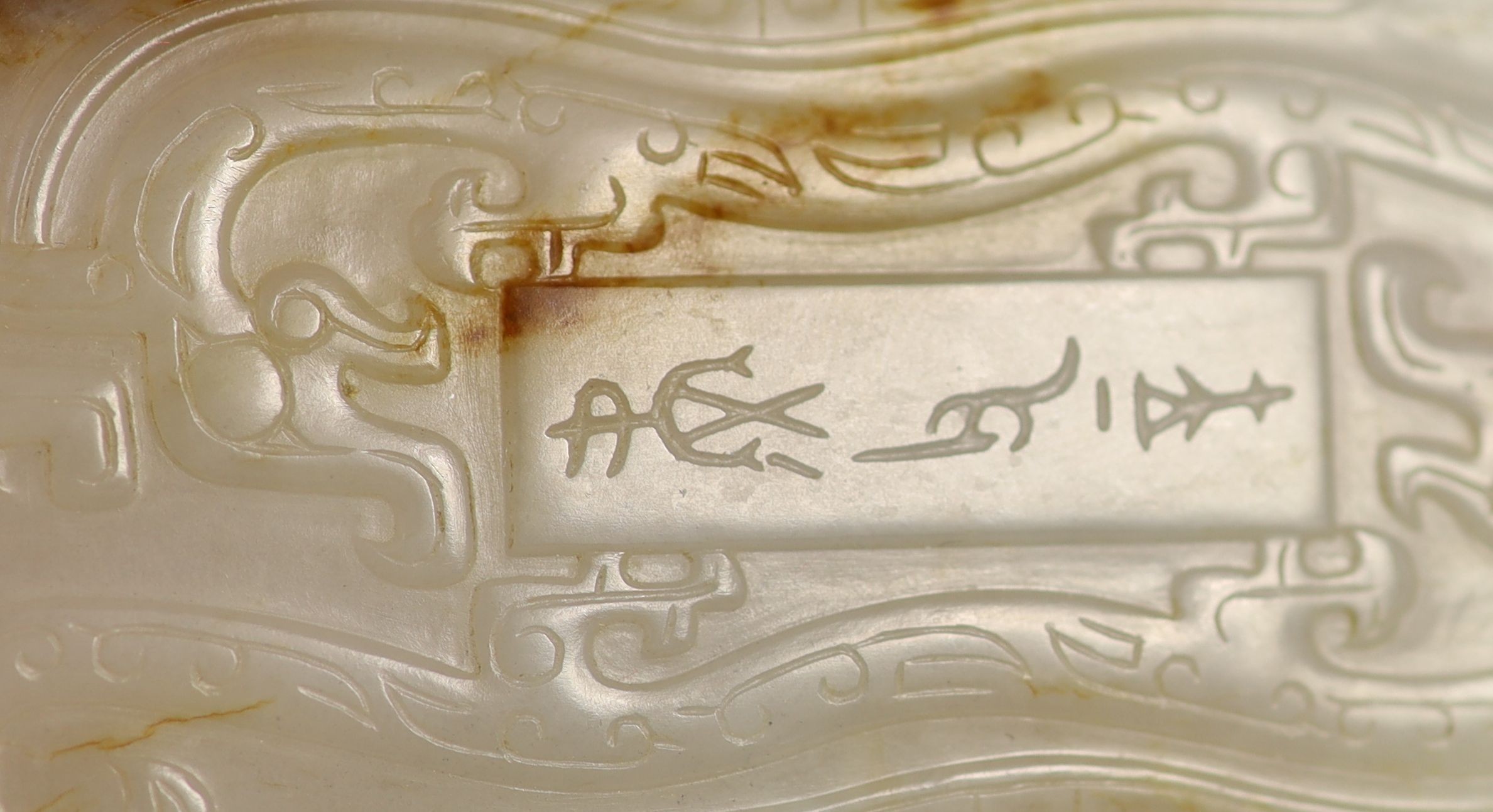 A Chinese archaistic white and brown jade box and cover, 8.3 x 4.3 cm